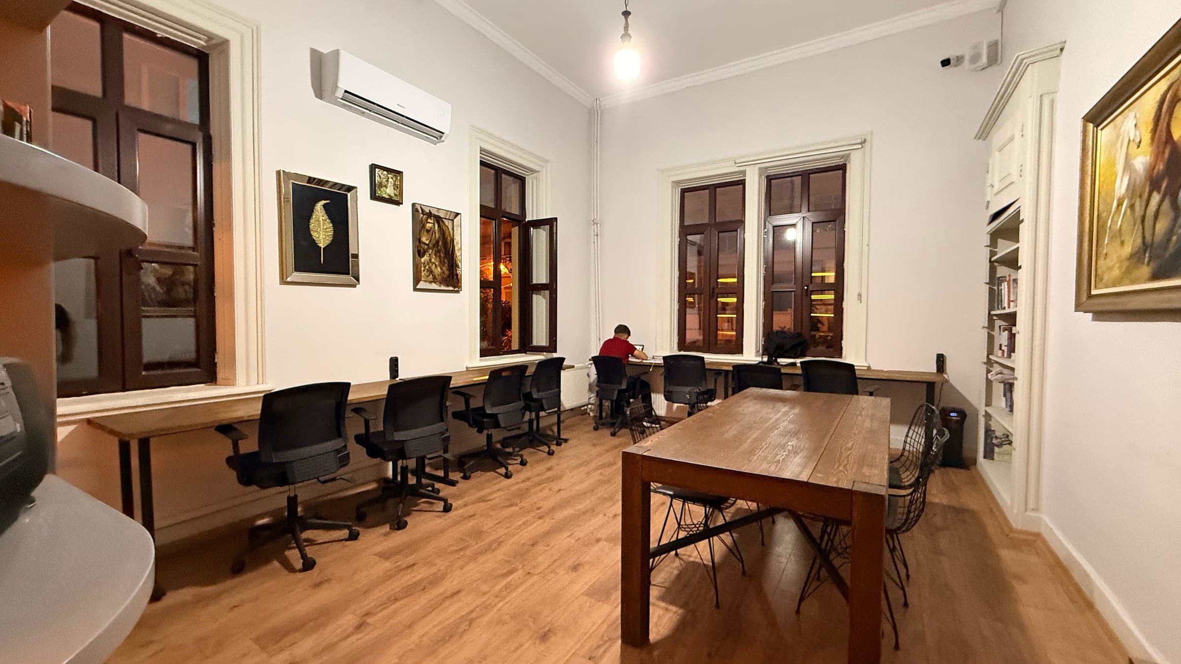 Pencere önünde prizli çalışma masaları ve ortak ahşap masa