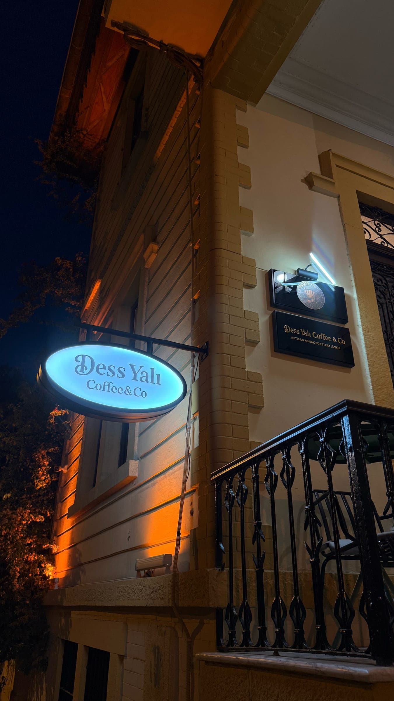 Gece aydınlatılmış Dess Yalı Coffee & Co tabelası ve binanın cephesi